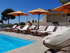 a group of chairs and umbrellas next to a swimming pool at Hotel Orsa Maggiore in Anacapri