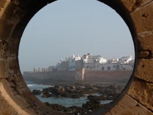 a view of a city through a round window at Riad Maison Du Sud in Essaouira
