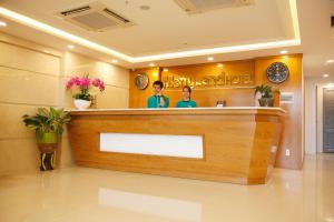 two people standing at a counter in a salon at Merry Land Hotel Da Nang in Danang
