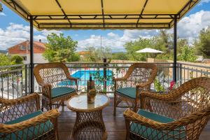 une terrasse avec des chaises, une table et une piscine dans l'établissement Villa Otavia, à Šibenik