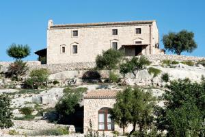 an old stone house on a hill with trees at Valle dell'Acanto in Modica