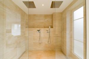 a bathroom with a shower with a glass door at Hotel Villa Seeschau - Adults only in Meersburg +59 photos