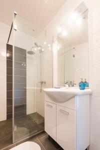 a white bathroom with a sink and a shower at Ombre Bleue in Toulouse