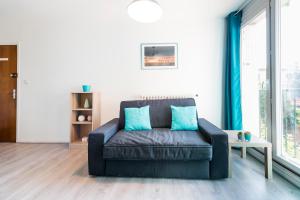 a leather couch in a living room with blue pillows at Ombre Bleue in Toulouse