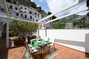 eine Terrasse mit einem Tisch und Stühlen auf dem Balkon in der Unterkunft Appartamento Paradiso in Amalfi