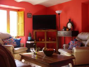 a living room with red walls and a flat screen tv at Il Monte Farmhouse in Torricella Peligna