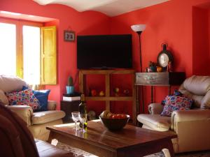 sala de estar con paredes rojas y TV de pantalla plana. en Il Monte Farmhouse, en Torricella Peligna