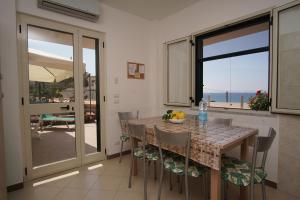 a kitchen with a table and chairs with a view of the ocean at Residence San Salvatore in Palinuro