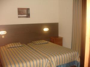 1 dormitorio con 1 cama con manta a rayas en Hotel Ribeira Grande, en Ribeira Grande