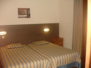 Un dormitorio con una cama con una manta a rayas. en Hotel Ribeira Grande, en Ribeira Grande