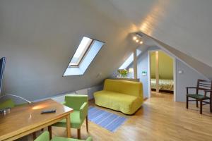 uma sala de estar com uma cadeira amarela e uma mesa em Ośrodek Kwaskowa em Kazimierz Dolny