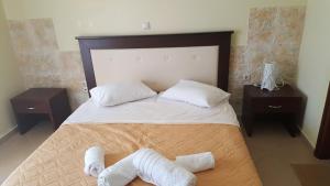 una camera da letto con un grande letto con asciugamani di Koxyli Studios a Vassiliki