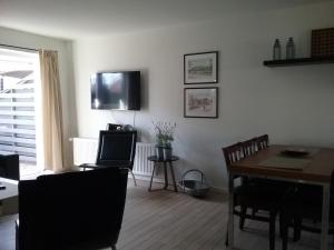 a living room with a table and a television on the wall at Hals Hotel ferielejlighed in Hals