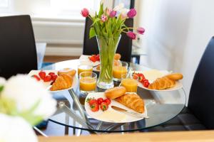 a table topped with plates of pastries and orange juice at Wordsworth Apartment Irene court in Cockermouth