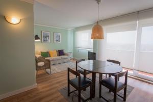 a living room with a table and chairs and a couch at Hotel Apartamento Solverde in Espinho