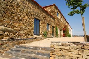 Quinta da Veiga في Covas do Douro: مبنى حجري امامه درج