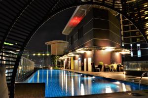 a swimming pool in a building at night at Holi Afiniti Themed Suites in Nusajaya