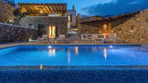 a swimming pool in a villa at night at Mykonos Panormos Villas in Mykonos