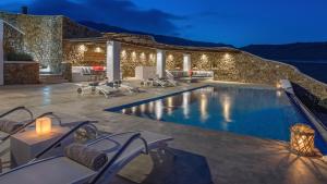a villa with a swimming pool at night at Mykonos Panormos Villas in Mykonos