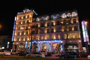 um edifício iluminado com carros estacionados em frente em Grand Boss Hotel em Yilan City