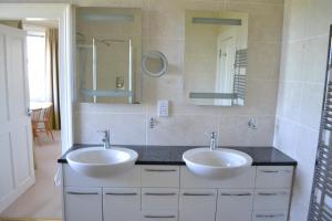 a bathroom with two sinks and a mirror at Burnside Farm B & B in Girvan