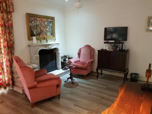 a living room with two chairs and a fireplace at Sherwood's Country House in Tzaneen