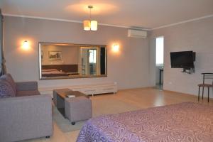 a living room with a bed and a tv in it at Apartments on Negruzzi 6/2 in Chişinău