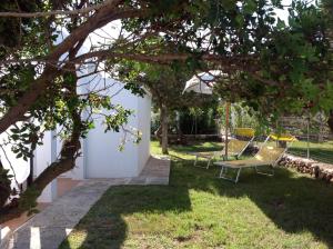 a yard with two chairs and an umbrella at Chalet Marivent in Cala en Bosc