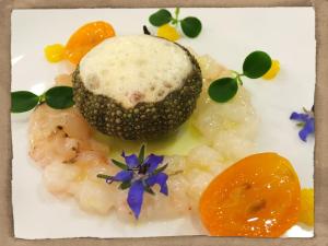 ein Teller mit Essen mit einer Wüste mit einer Blume darauf in der Unterkunft Hotel Restaurant Les Capucins in Belfort