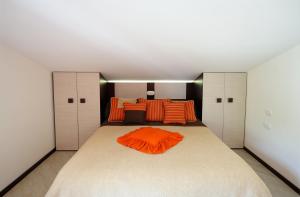 Appartamento Paradiso في أمالفي: غرفة نوم مع سرير كبير مع وسائد برتقالية