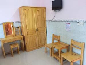 Zimmer mit Holzmöbeln und einem TV an der Wand in der Unterkunft Y Thu Guesthouse in Phu Quoc