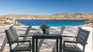 a table with two chairs and a view of the ocean at Mykonos Panormos Villas in Mykonos