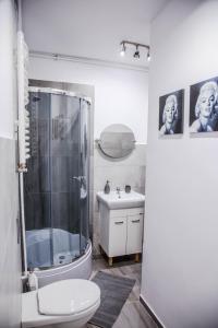 een badkamer met een douche, een toilet en een wastafel bij Apartament Centrum Harcerska in Gdynia