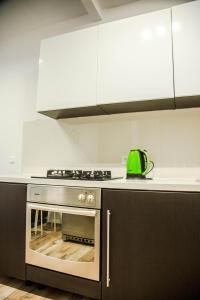 een keuken met een fornuis en een groene waterkoker bij Apartament Centrum Harcerska in Gdynia