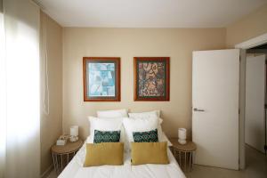 a bedroom with a white bed with two pillows at Increible apartamento a 2 minutos de la playa de MembrilloSuites in Playa Paraiso