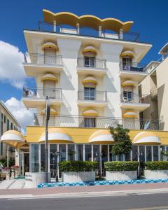 ein Gebäude mit Balkon in einer Stadtstraße in der Unterkunft Hotel Gardenia in Bellaria-Igea Marina
