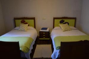 a room with two beds and a table with a night stand at Venta la Aurora in Beleño