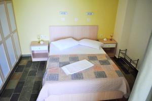 1 dormitorio con 1 cama grande y 2 mesitas de noche en To Livadi, en Lefkogeia