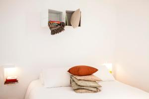 a bedroom with white walls and a bed with pillows at DestinationBCN Marimon Apartment in Barcelona