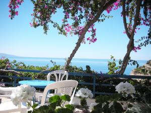 a table and chairs with the ocean in the background at Hotel Hariklia in Agia Galini