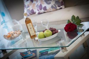 una mesa de cristal con una botella de vino y un bol de fruta en Litinakis Studios, en Agia Marina de Nea Kydonia