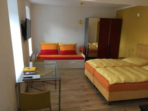 a bedroom with two beds and a table and a desk at Alte Post Greifenstein in Greifenstein