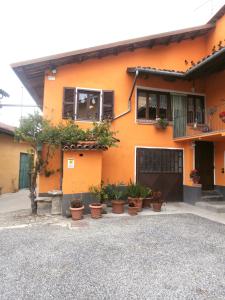 an orange house with potted plants in front of it at B&B Rumanot in Dogliani