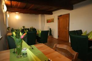 a dining room with a table and green chairs at Gasthof Zum Kramer in Gurk