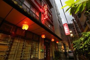 un edificio con insegne al neon sul lato di una strada di Ku Shan Yuan Hotel a Taipei