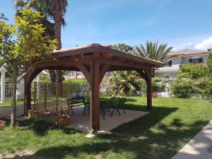 un pabellón de madera con una mesa y sillas en un patio en B&B Magna Grecia, en Lamezia Terme