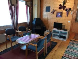 a living room with a table and chairs and a television at Hannunluhdan Lomamökit in Karijoki