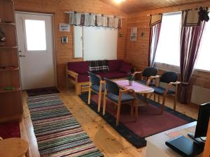 a living room with a couch and a table and chairs at Hannunluhdan Lomamökit in Karijoki