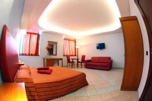 sypialnia z łóżkiem i czerwoną kanapą w obiekcie Hotel Stefano a Melito w mieście Melito di Napoli