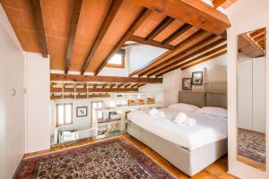 1 dormitorio con cama blanca grande y techo de madera en Bohémienne Penthouse, en Florencia